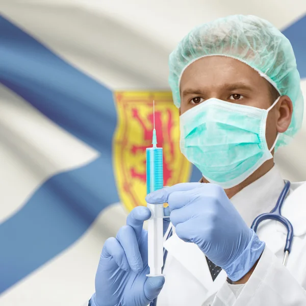 Médecin avec une seringue dans les mains et la série des drapeaux province du Canada - Nouvelle-Écosse — Photo