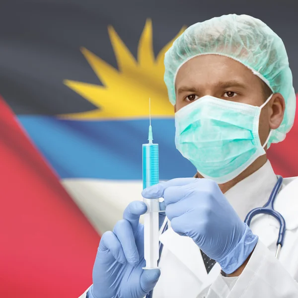 Доктор с шприц в руках и флаг серии - Антигуа и Барбуда — стоковое фото