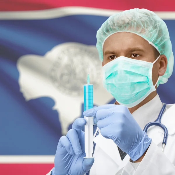 Médecin avec une seringue dans les mains et les États américains drapeaux series - Wyoming — Photo
