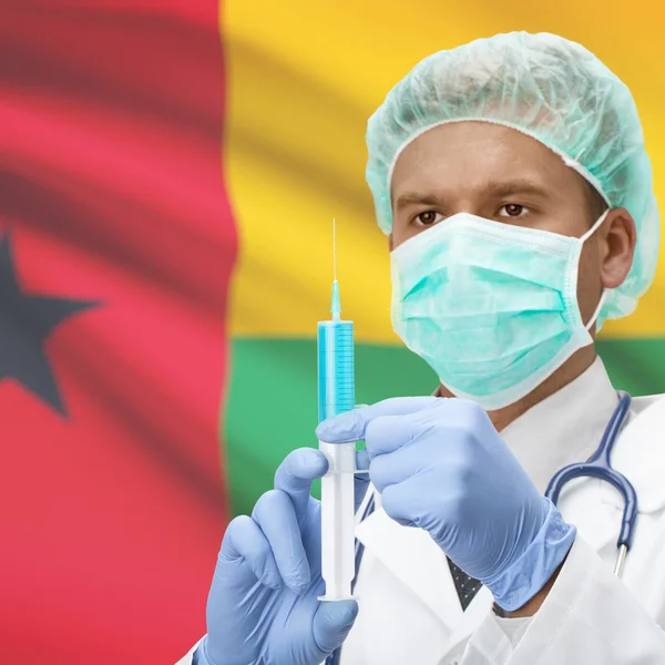 Medico con la siringa in mano e bandiere - Guinea-Bissau — Foto Stock