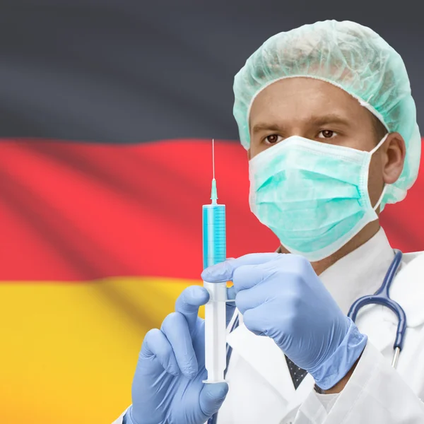 Médico con jeringa en las manos y la bandera de la serie - Alemania —  Fotos de Stock