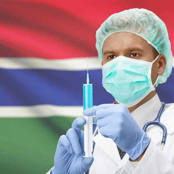 Médico con jeringa en las manos y la bandera de la serie - Gambia — Foto de Stock