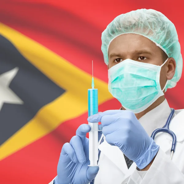 Médecin avec une seringue dans les mains et drapeau séries - le Timor oriental — Photo