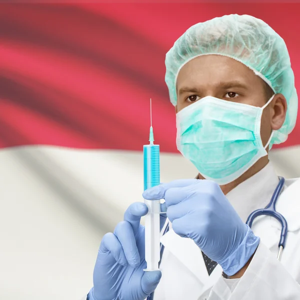 Médico con jeringa en las manos y la bandera de la serie - Indonesia —  Fotos de Stock
