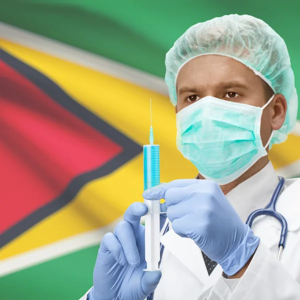 Medico con la siringa in mano e bandiere - Guyana — Foto Stock