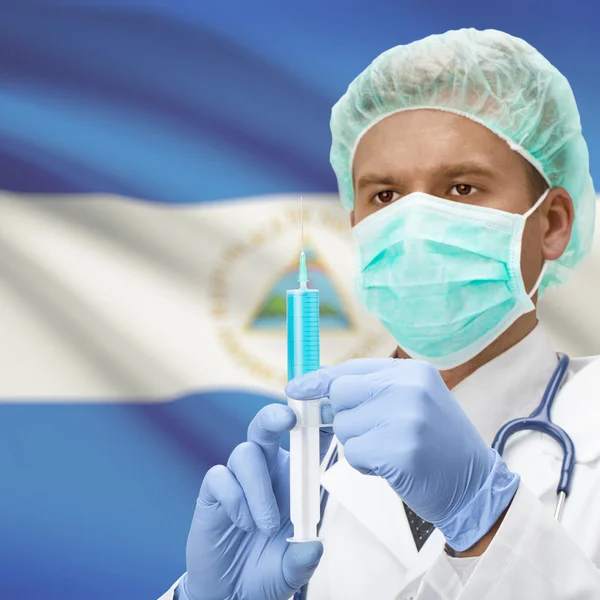Médecin avec une seringue dans les mains et la série des drapeaux - Nicaragua — Photo