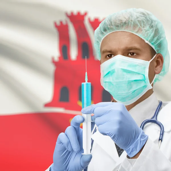 Médecin avec une seringue dans les mains et la série des drapeaux - Gibraltar — Photo
