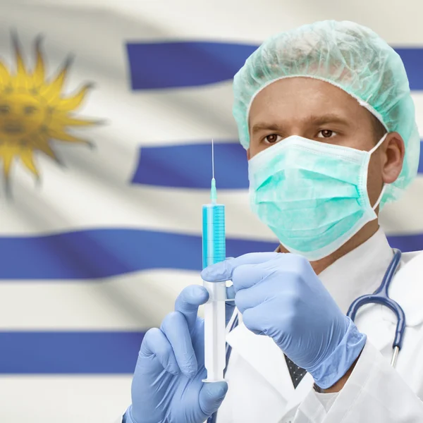 Médecin avec une seringue dans les mains et la série des drapeaux - Uruguay — Photo