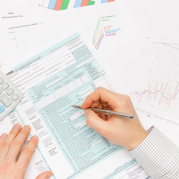 Male filling out 1040 US Tax Form with silver pen - indoors shot — Stock Photo, Image