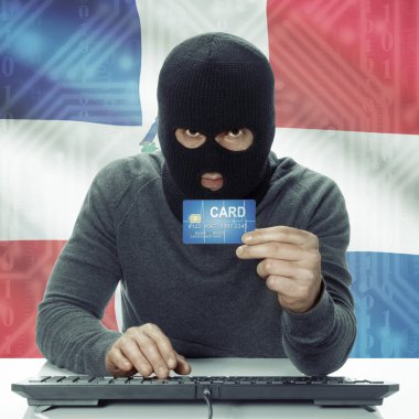 Dark-skinned hacker with flag on background holding credit card in hand - Dominican Republic