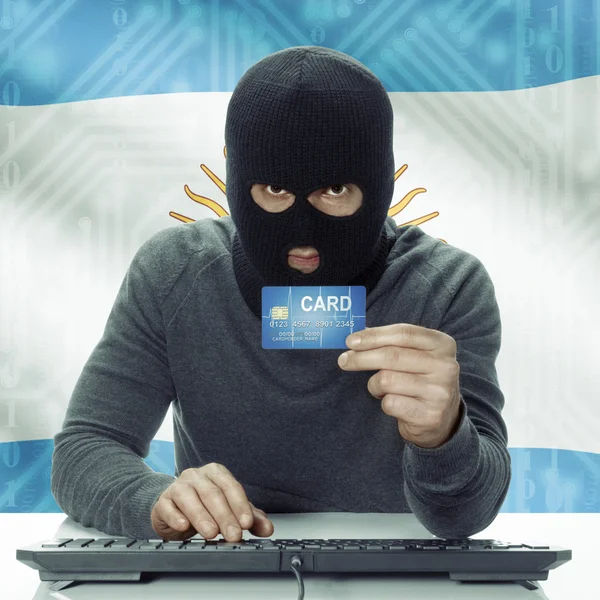 Dark-skinned hacker with flag on background holding credit card in hand - Argentina —  Fotos de Stock