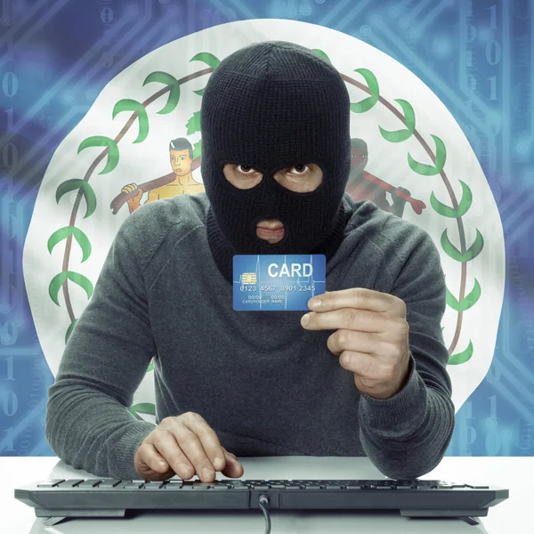 Dark-skinned hacker with flag on background holding credit card in hand - Belize — 스톡 사진
