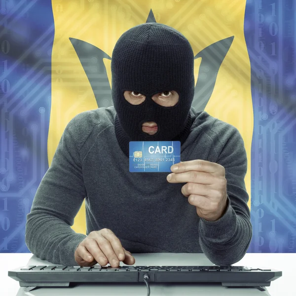 Dark-skinned hacker with flag on background holding credit card in hand - Barbados — Stock Photo, Image