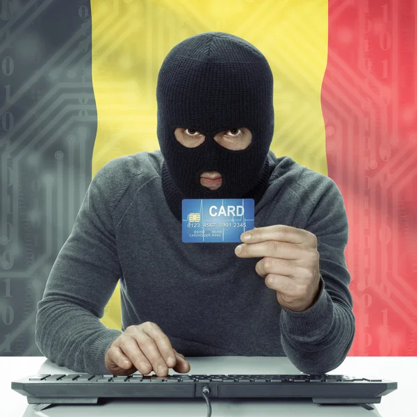 Dark-skinned hacker with flag on background holding credit card in hand - Belgium — Stock Photo, Image