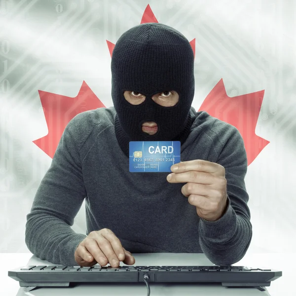 Темнокожая хакер с флагом на фоне проведения кредитной карты в руки - Канада — стоковое фото