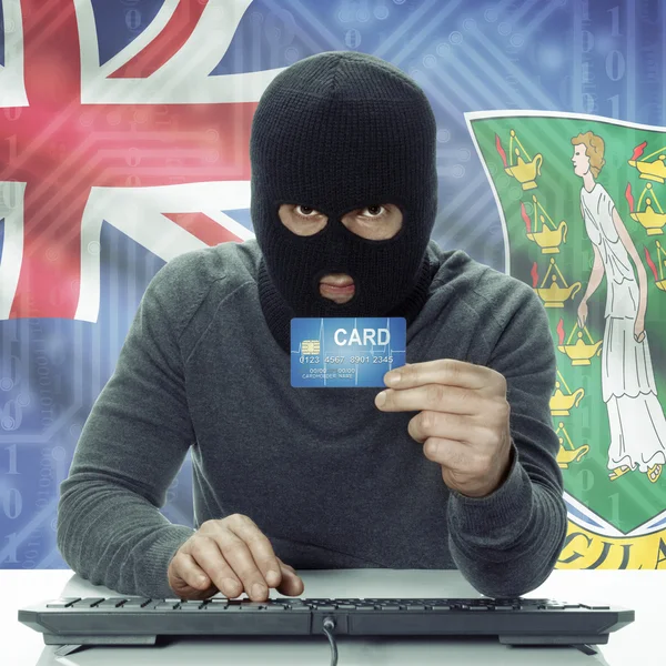 Dark-skinned hacker with flag on background holding credit card in hand - British Virgin Islands —  Fotos de Stock
