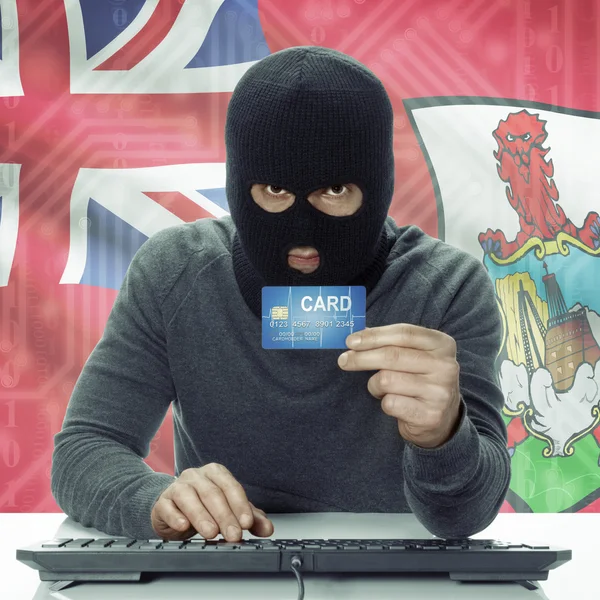 Dark-skinned hacker with flag on background holding credit card in hand - Bermuda —  Fotos de Stock