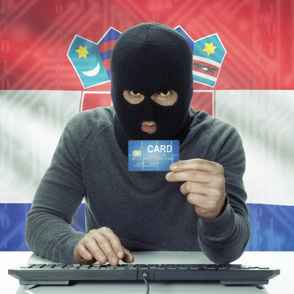 Dark-skinned hacker with flag on background holding credit card in hand - Croatia — Stock Photo, Image