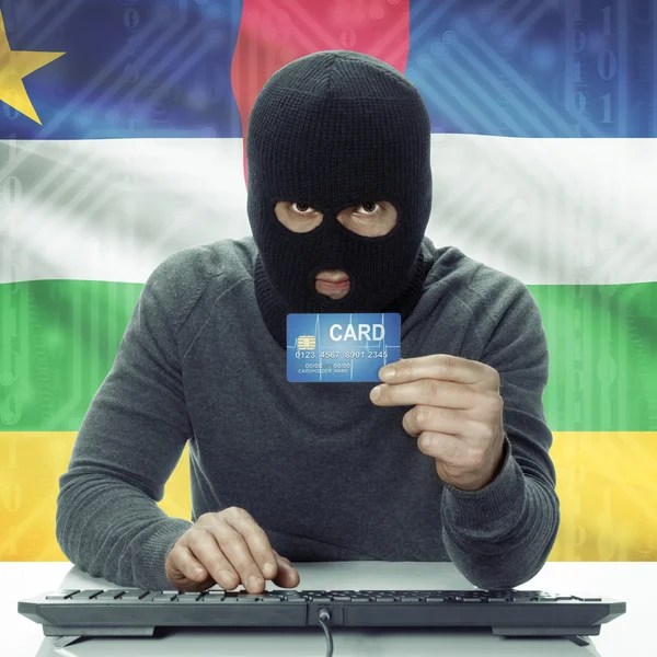 Dark-skinned hacker with flag on background holding credit card in hand - Central African Republic — Foto de Stock