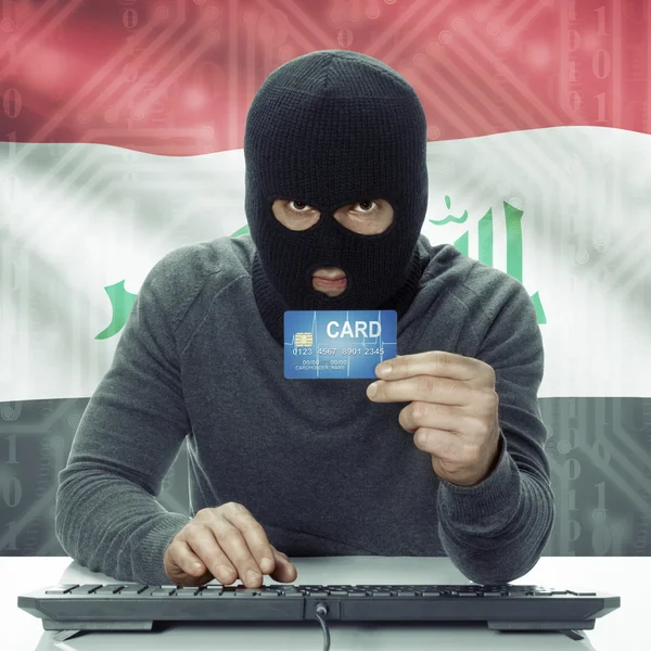 Dark-skinned hacker with flag on background holding credit card in hand - Iraq — Stock Photo, Image