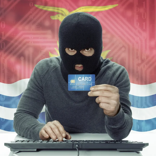 Dark-skinned hacker with flag on background holding credit card in hand - Kiribati — Foto de Stock