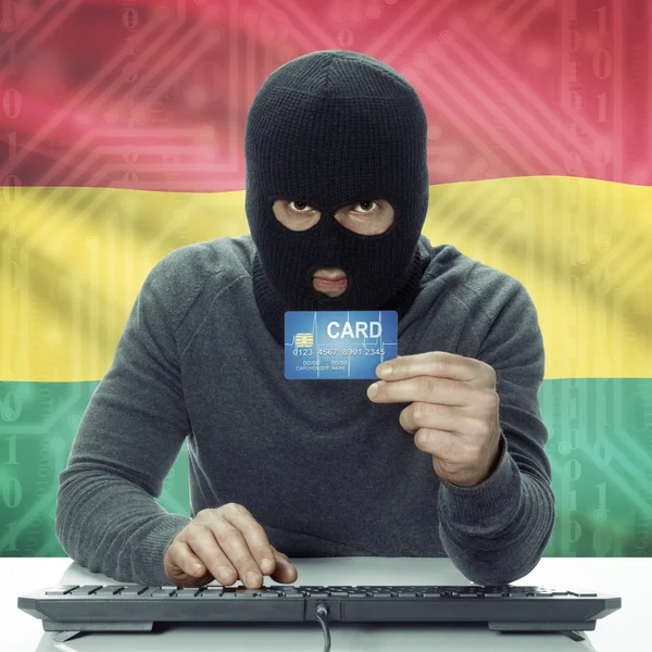 Dark-skinned hacker with flag on background holding credit card in hand - Ghana — Zdjęcie stockowe