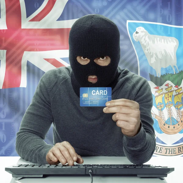 Dark-skinned hacker with flag on background holding credit card in hand - Falkland Islands —  Fotos de Stock