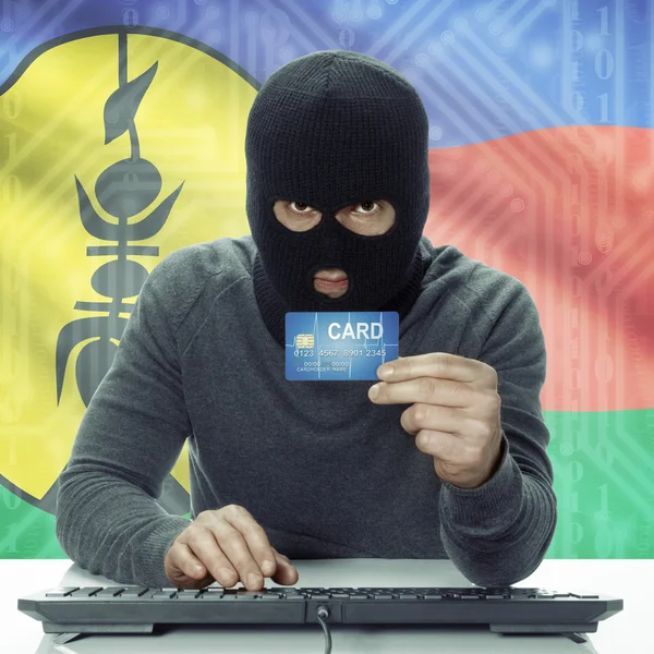 Dark-skinned hacker with flag on background holding credit card in hand - New Caledonia — Zdjęcie stockowe