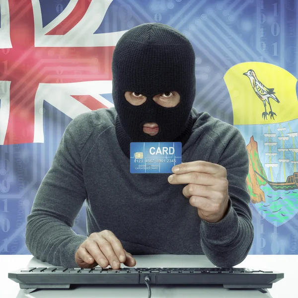 Dark-skinned hacker with flag on background holding credit card in hand - Saint Helena —  Fotos de Stock