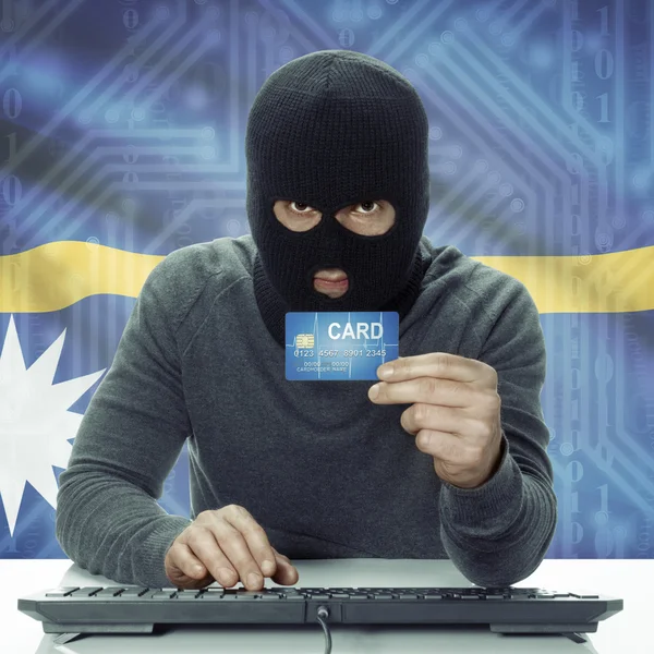 Dark-skinned hacker with flag on background holding credit card in hand - Nauru — Foto Stock