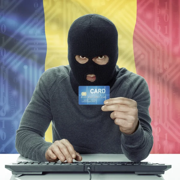 Dark-skinned hacker with flag on background holding credit card in hand - Romania — 图库照片
