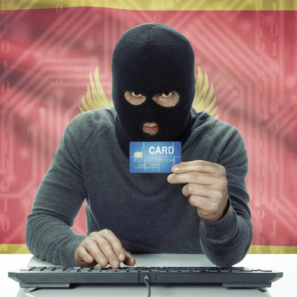 Dark-skinned hacker with flag on background holding credit card in hand - Montenegro — Stock fotografie