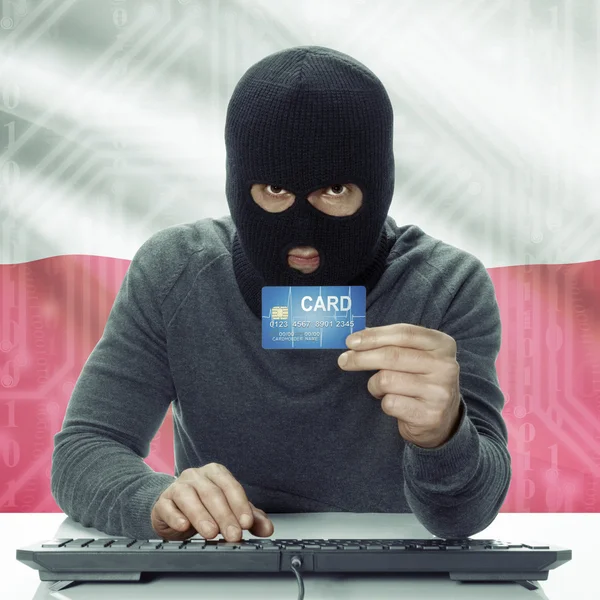 Dark-skinned hacker with flag on background holding credit card in hand - Poland — Foto de Stock