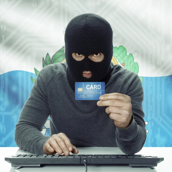 Dark-skinned hacker with flag on background holding credit card in hand - San Marino — Stock Photo, Image