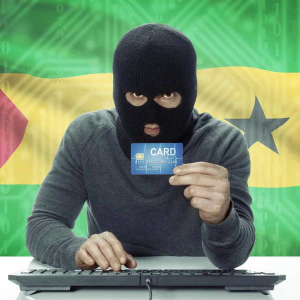 Dark-skinned hacker with flag on background holding credit card in hand - Sao Tome and Principe — Zdjęcie stockowe