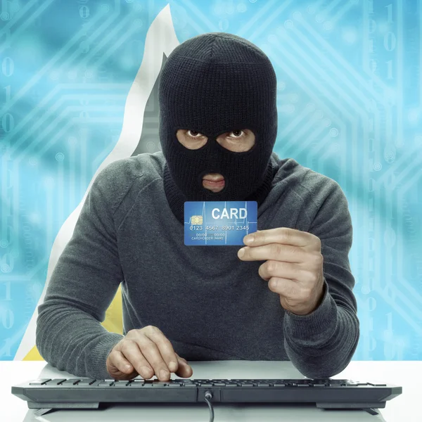 Dark-skinned hacker with flag on background holding credit card in hand - Saint Lucia — Stok fotoğraf