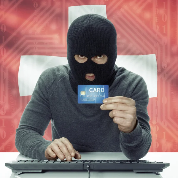 Dark-skinned hacker with flag on background holding credit card in hand - Switzerland — Stock Photo, Image