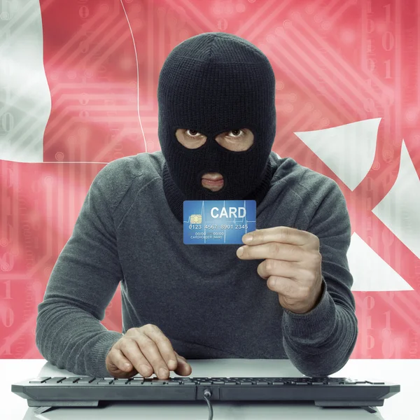 Dark-skinned hacker with flag on background holding credit card in hand - Wallis and Futuna —  Fotos de Stock