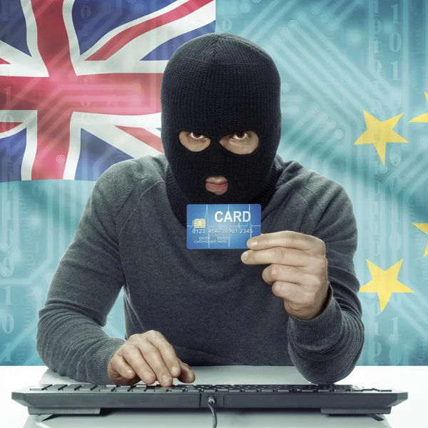 Dark-skinned hacker with flag on background holding credit card in hand - Tuvalu —  Fotos de Stock