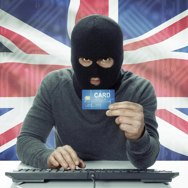 Dark-skinned hacker with flag on background holding credit card in hand - United Kingdom —  Fotos de Stock