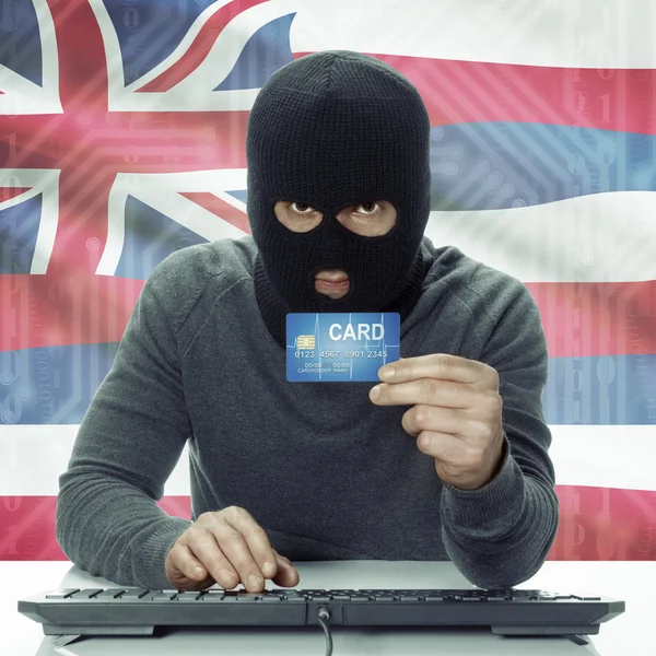 Dark-skinned hacker with USA states flag on background holding card in hand - Hawaii —  Fotos de Stock