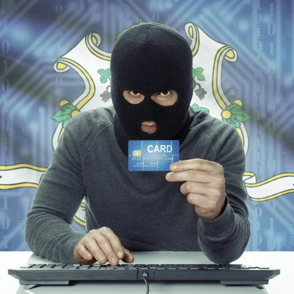 Dark-skinned hacker with USA states flag on background holding card in hand - Connecticut — Stock fotografie