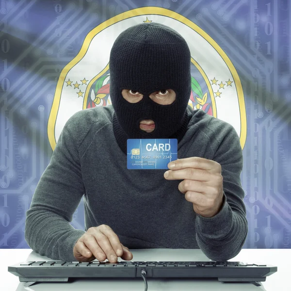 Dark-skinned hacker with USA states flag on background holding card in hand - Minnesota — Stock fotografie
