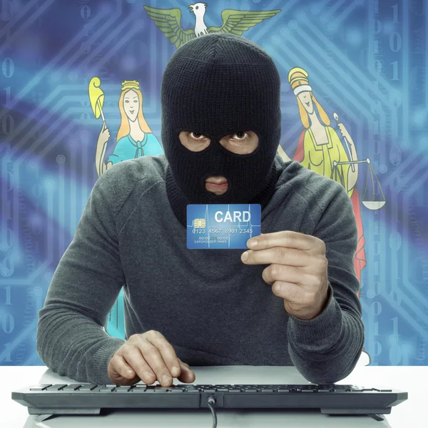 Dark-skinned hacker with USA states flag on background holding card in hand - New York — Stock Photo, Image