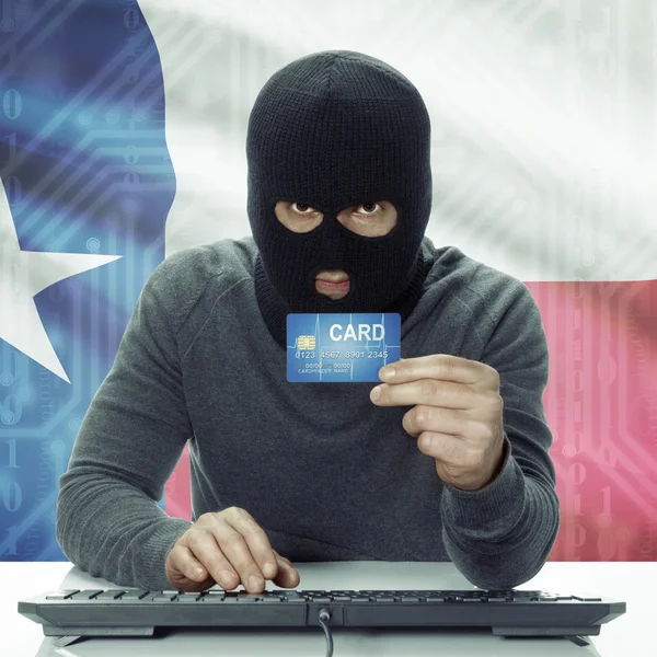 Dark-skinned hacker with USA states flag on background holding card in hand - Texas —  Fotos de Stock