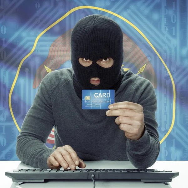 Dark-skinned hacker with USA states flag on background holding card in hand - Utah — Stock fotografie