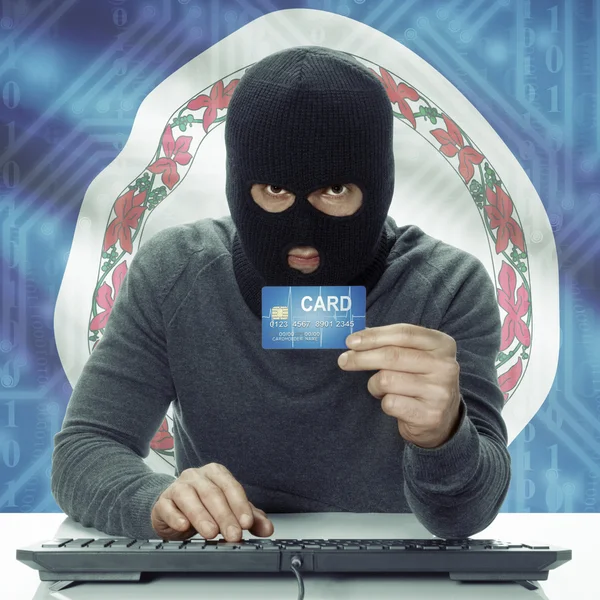 Dark-skinned hacker with USA states flag on background holding card in hand - Virginia — стокове фото
