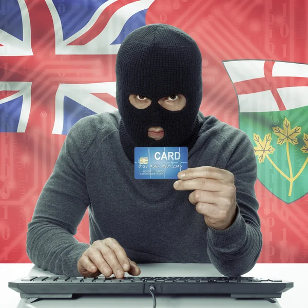 Dark-skinned hacker with Canadian province flag on background holding card - Ontario —  Fotos de Stock