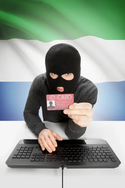 Hacker with flag on background holding ID card in hand - Sierra Leone — Stock Photo, Image