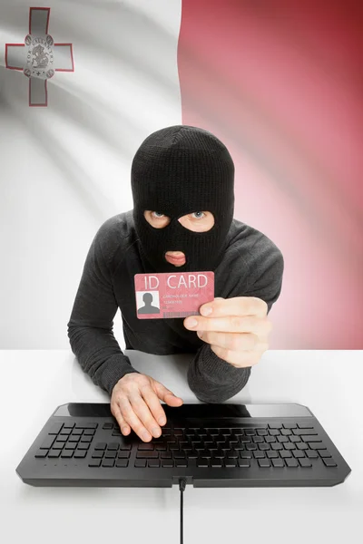 Hacker with flag on background holding ID card in hand - Malta — Stock Photo, Image